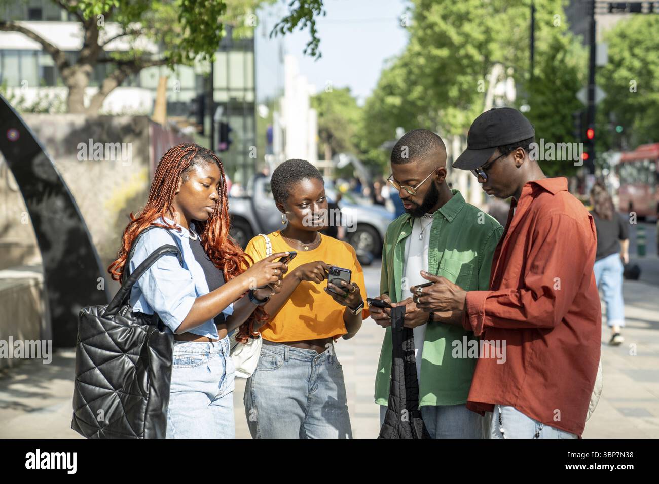 Disinterested black friends continue to use phones after meeting. Indifferent African American students addicted to gadgets, can not tear away from wo Stock Photo