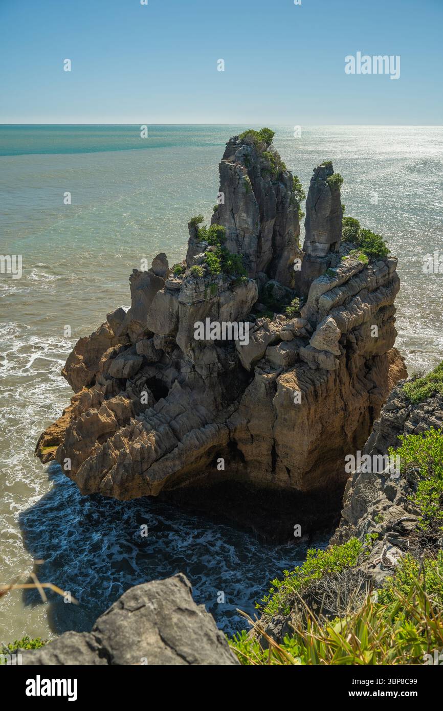 Towering limestone sea stacks rise from the turquoise ocean, shaped by ...