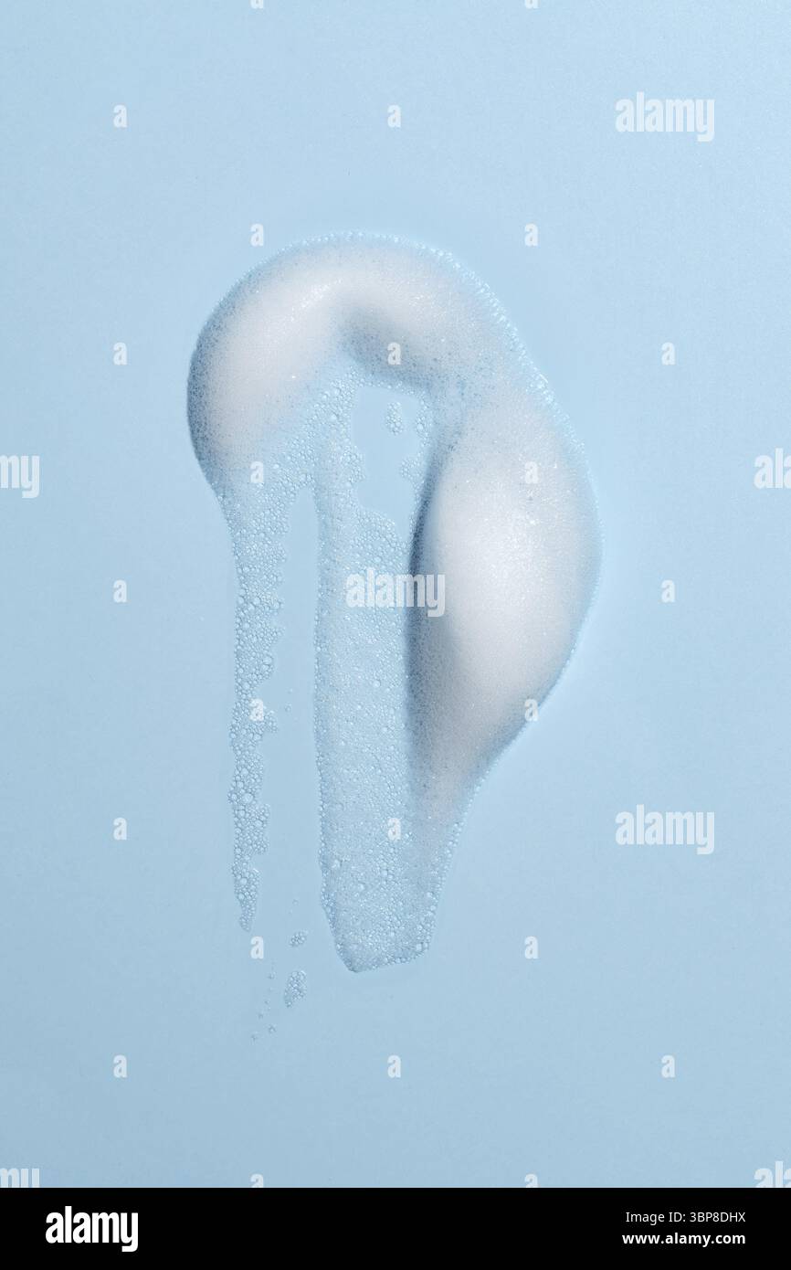 Weisse Reinigungsmittel Schaum Blasen Tropfen Abstrich isoliert auf blau. Seife, Duschgel, Shampoo Schaum Textur Nahaufnahme Stock Photo
