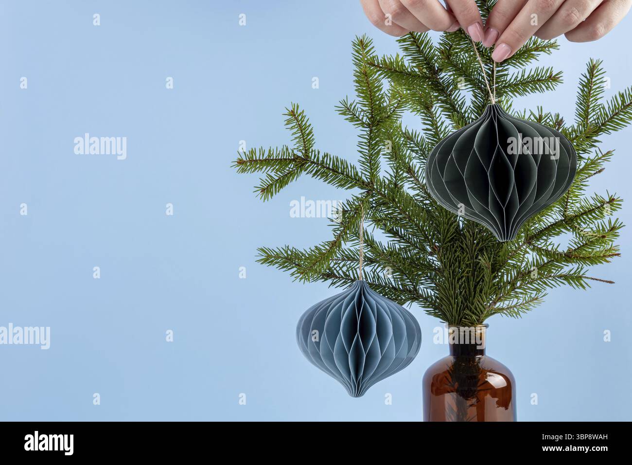 Weihnachtsdekoration aus Papierkugeln. Handgefertigte nordische Weihnachtsdekoration auf blauem Hintergrund. Boheme und skandinavisches Design. Selbs Stock Photo