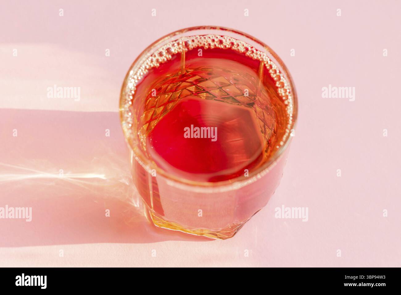 Glass of apple juice on pink background. Non alcoholic beverage Stock Photo