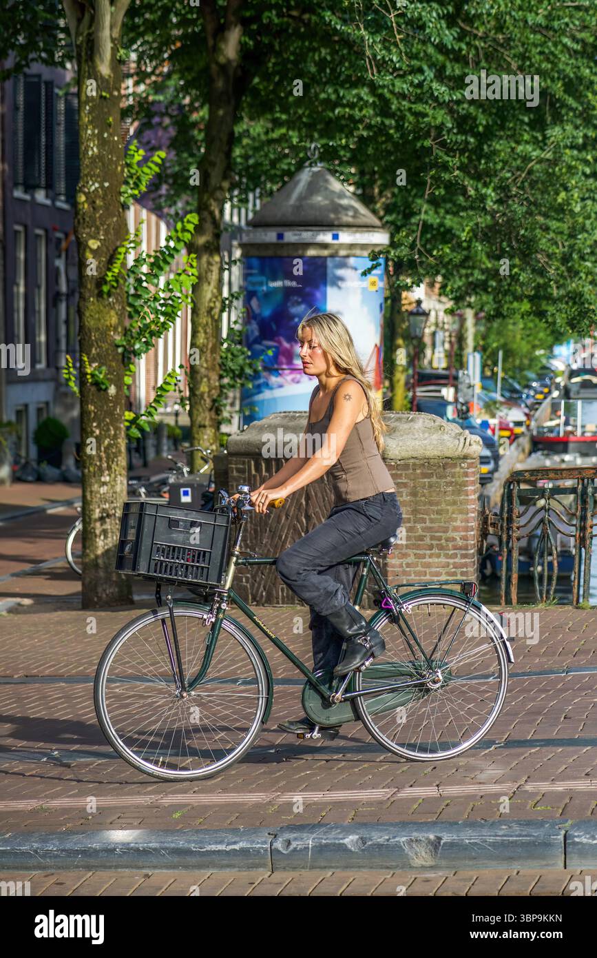 Street scenes in Amsterdam, Netherlands - young attractive blonde cyclist Stock Photo