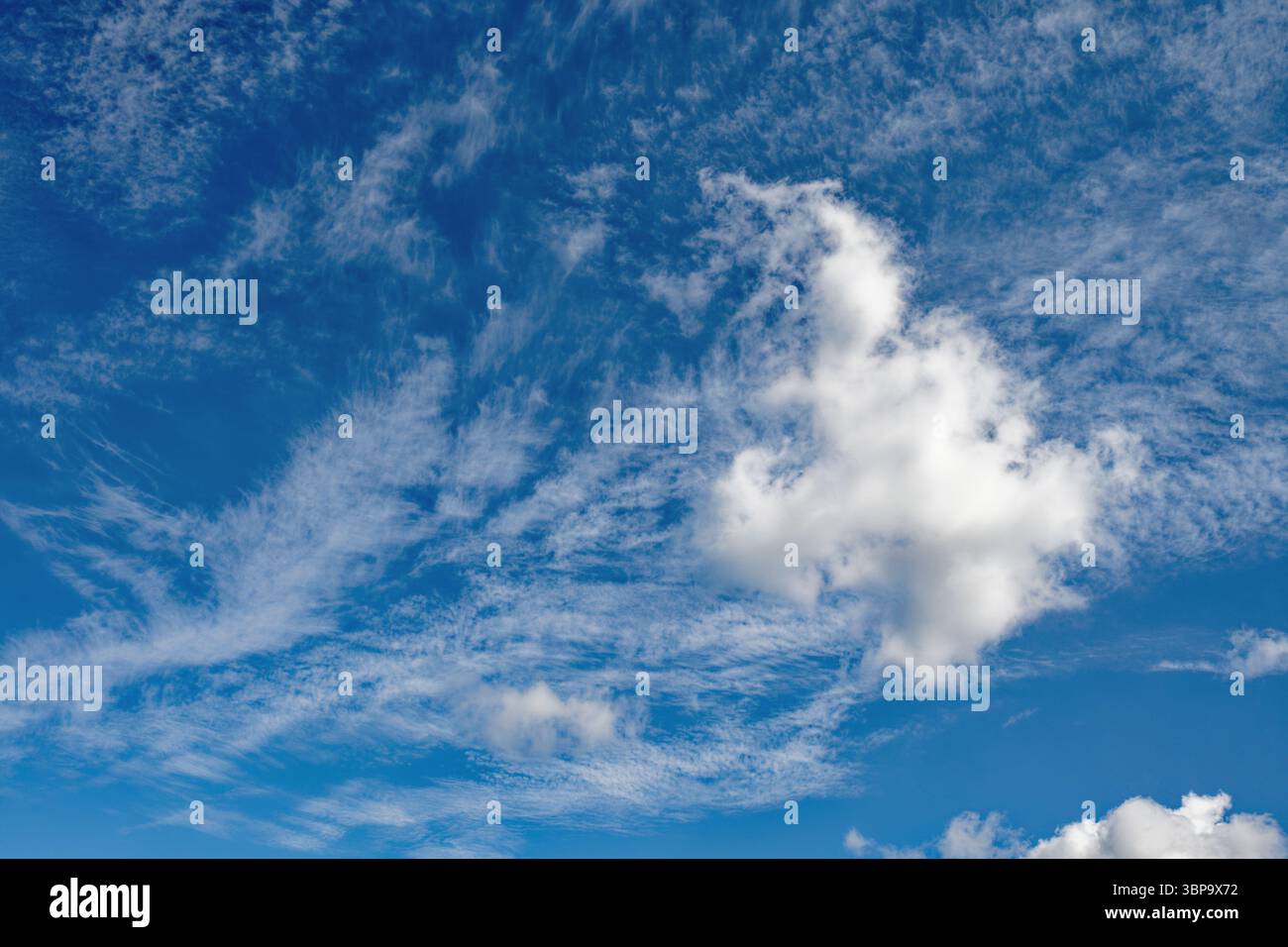 White wispy cloud formation against a blue sunny sky Stock Photo