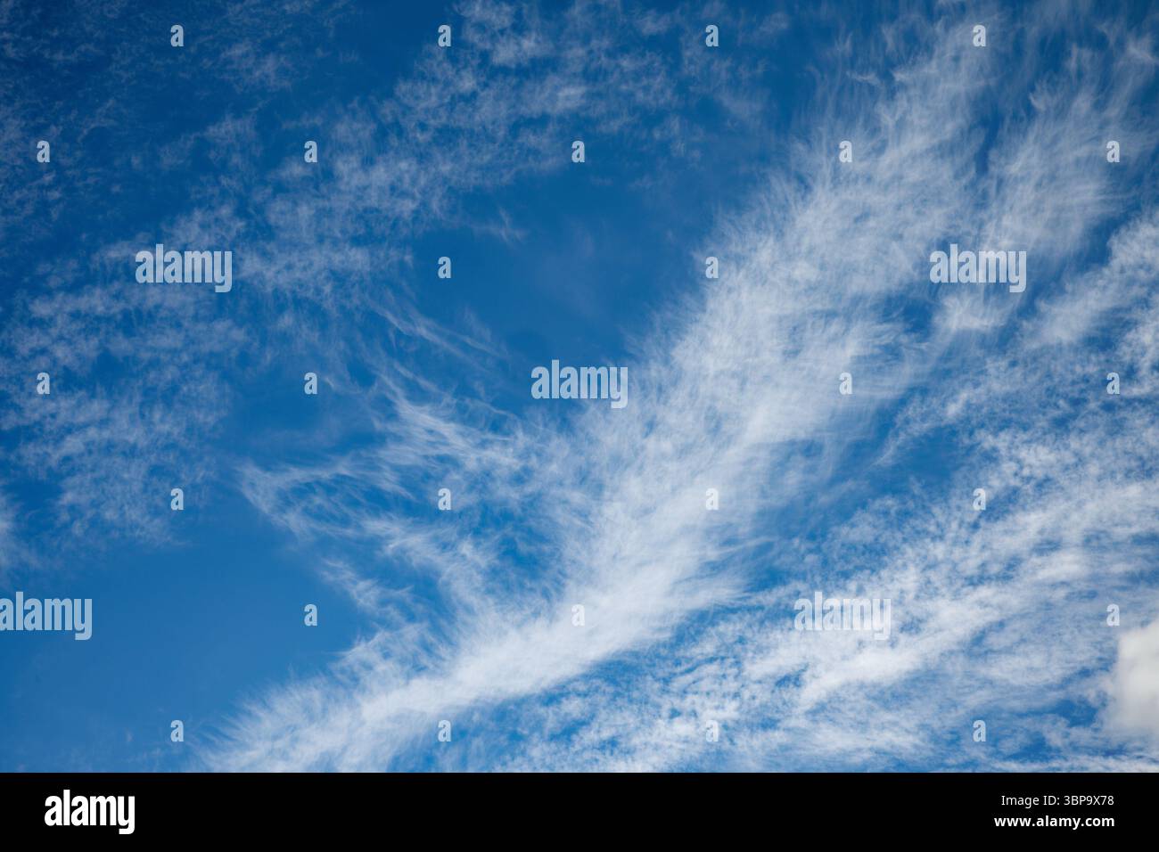 White wispy cloud formation against a blue sunny sky Stock Photo