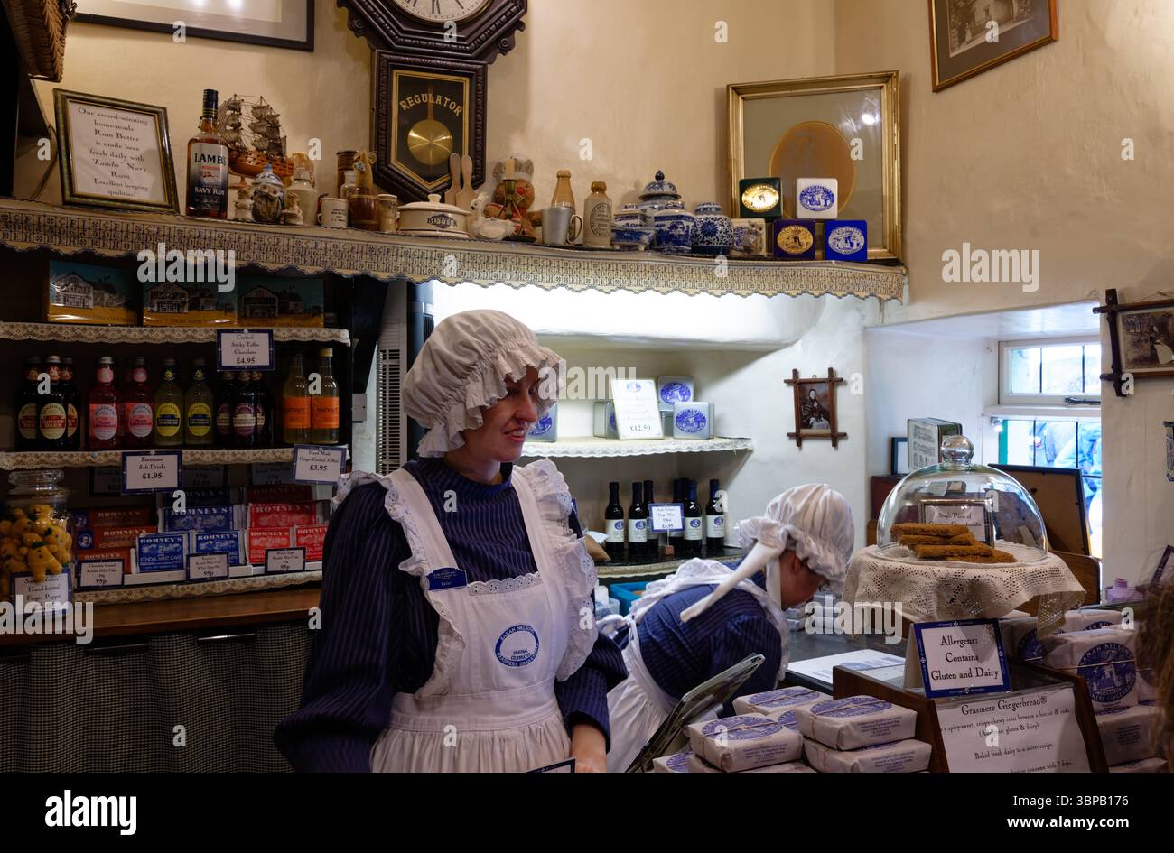 Serving staff in period traditional dress costume in the Grasmere gingerbread shop, Grasmere, Lake district, England Stock Photo