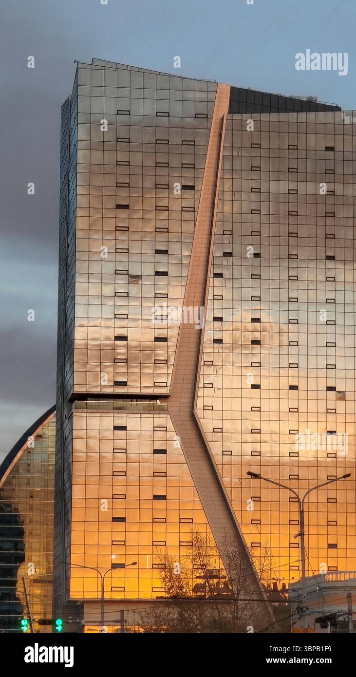 Glass facade of a tall building glows with sunset hues in Mongolia's ...