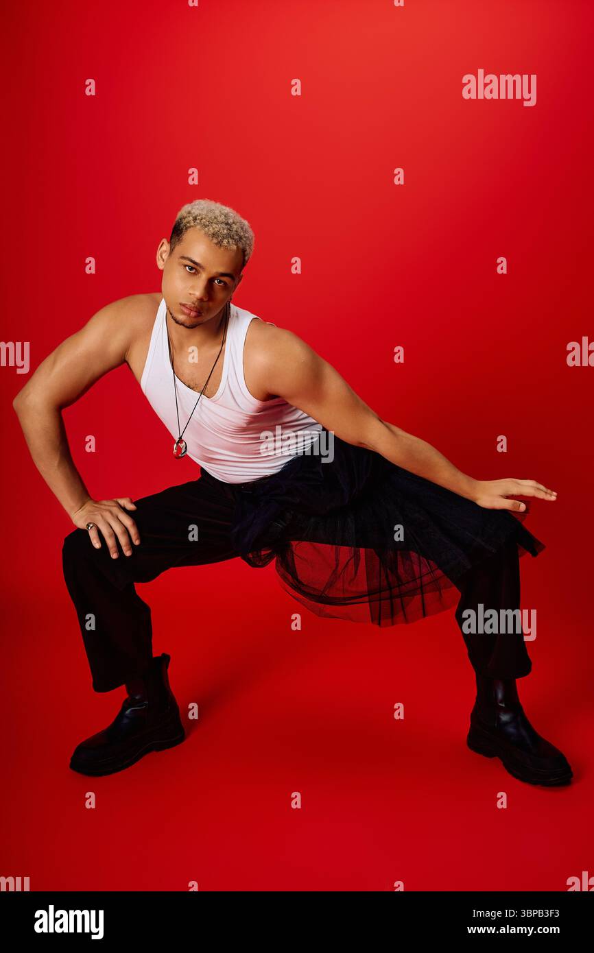 A young Black man in a tank top and pants strikes a dynamic, stylish ...