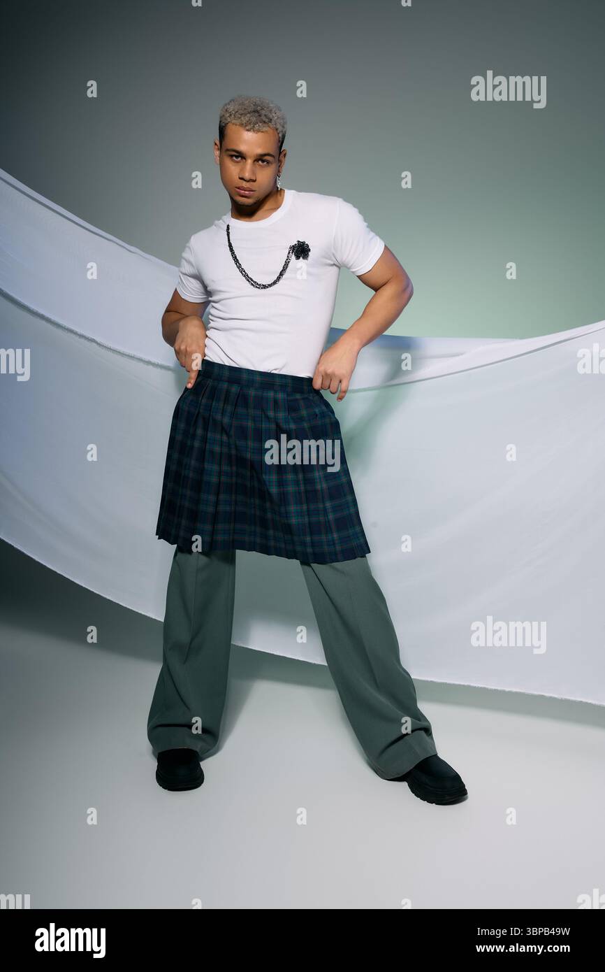 A young african american man confidently poses in a stylish outfit ...