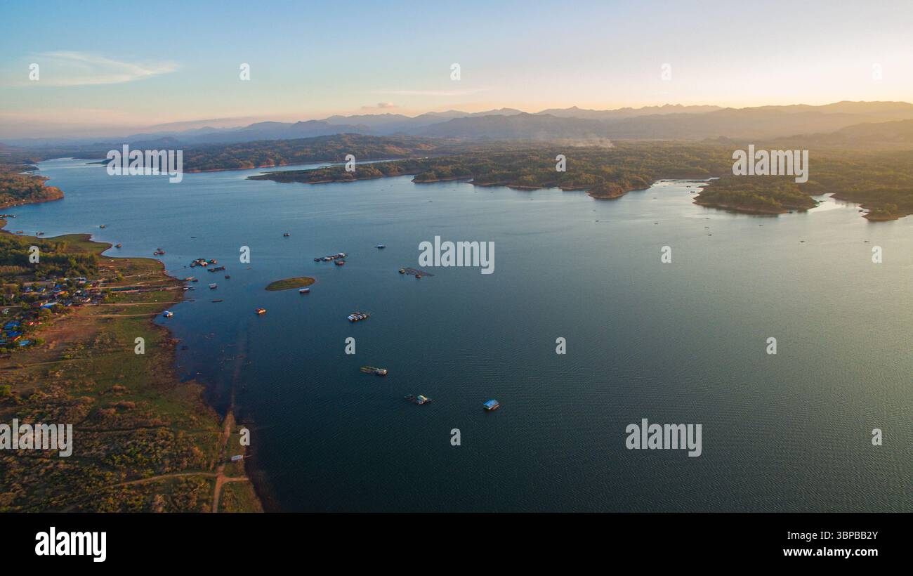 stunning aerial scene captures the meeting point of rugged mountains and endless lake. With vibrant cloudscapes and scattered islands, Vajiralongkorn Stock Photo