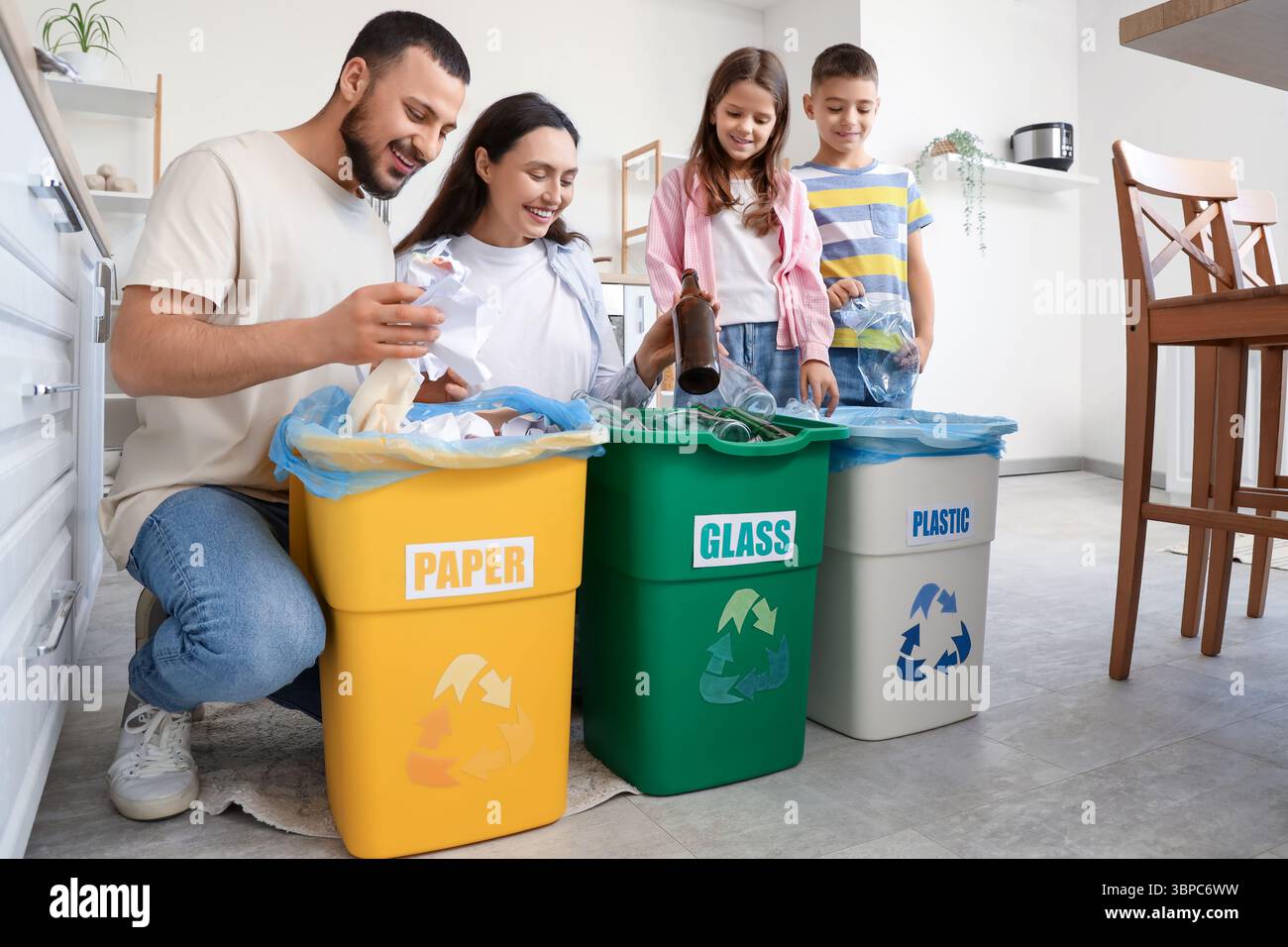 Family with containers sorting garbage in kitchen. Global Recycling Day ...