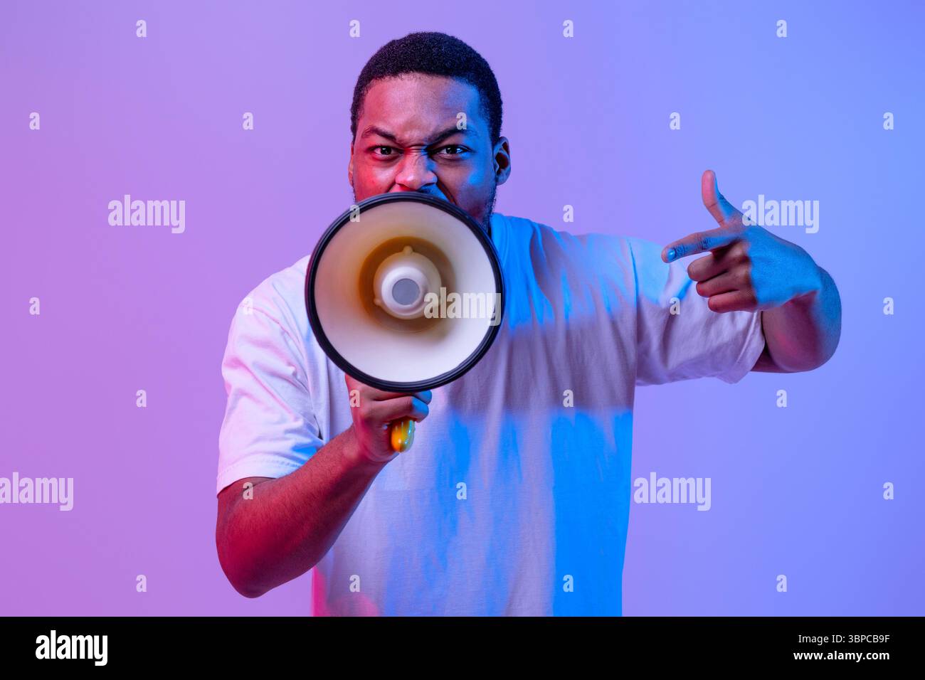 Agressive Black Guy Shouting Into Loudspeaker, Making Announcement And Emotionally Gesturing Stock Photo