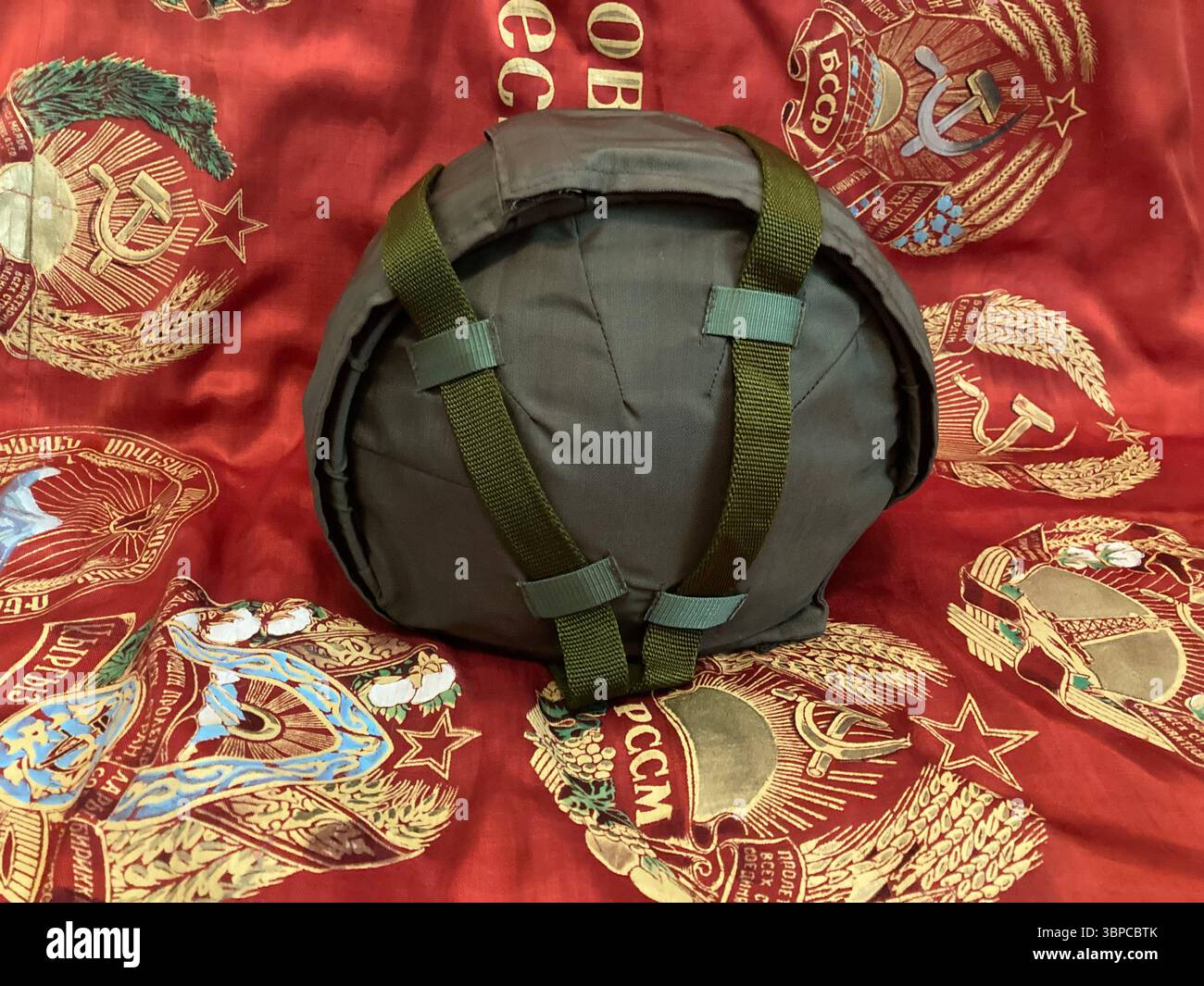 STSh-81 Soviet Steel Helmet Displayed on Red Soviet Banner – Military Collectible - Smartphone Captured Stock Image