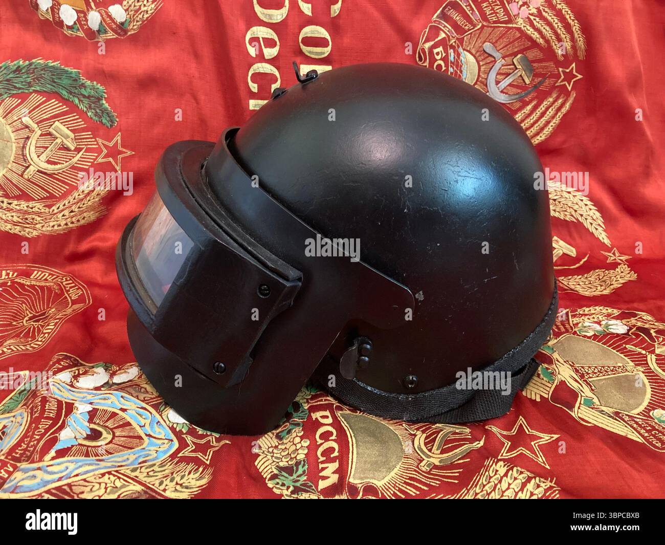 Black K6-3 Russian Ballistic Helmet on Soviet Banner - Smartphone Captured Stock Image