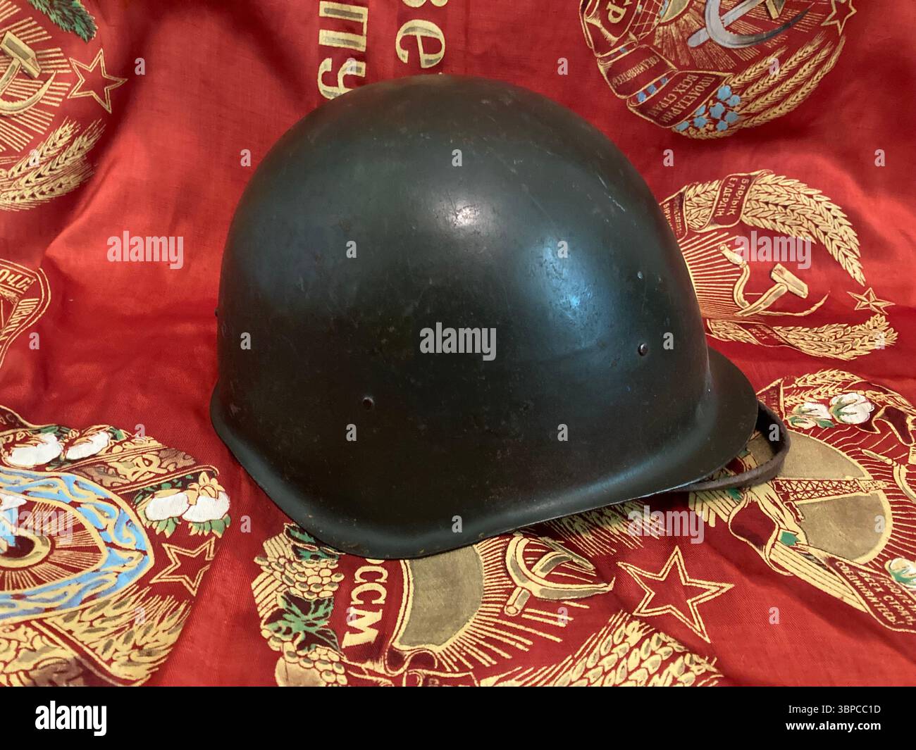 Czechoslovakian SSh-60 steel helmet on Soviet banner background - Smartphone Captured Stock Image