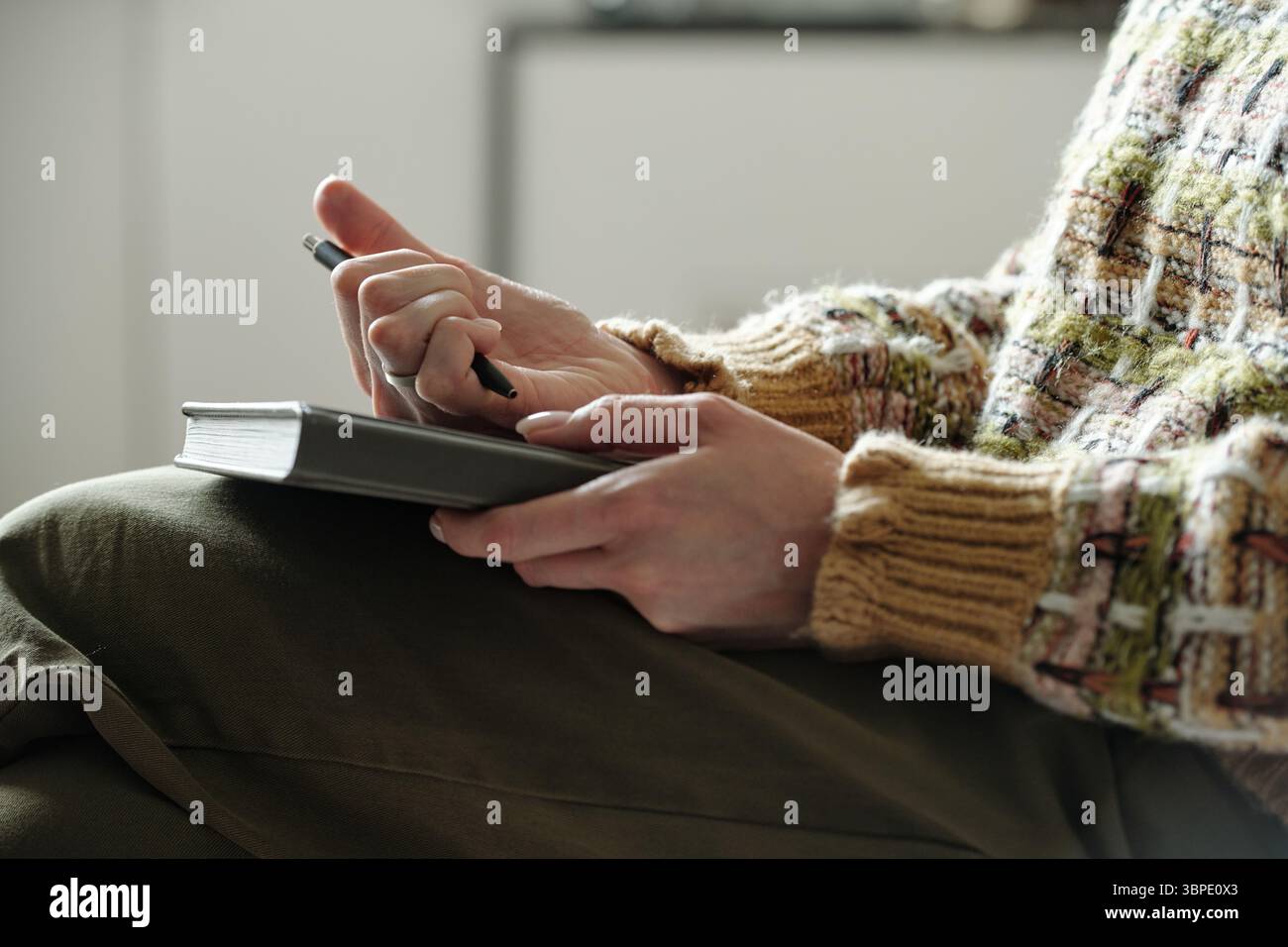 Young Woman Taking Notes during Therapy Session Indoors Stock Photo