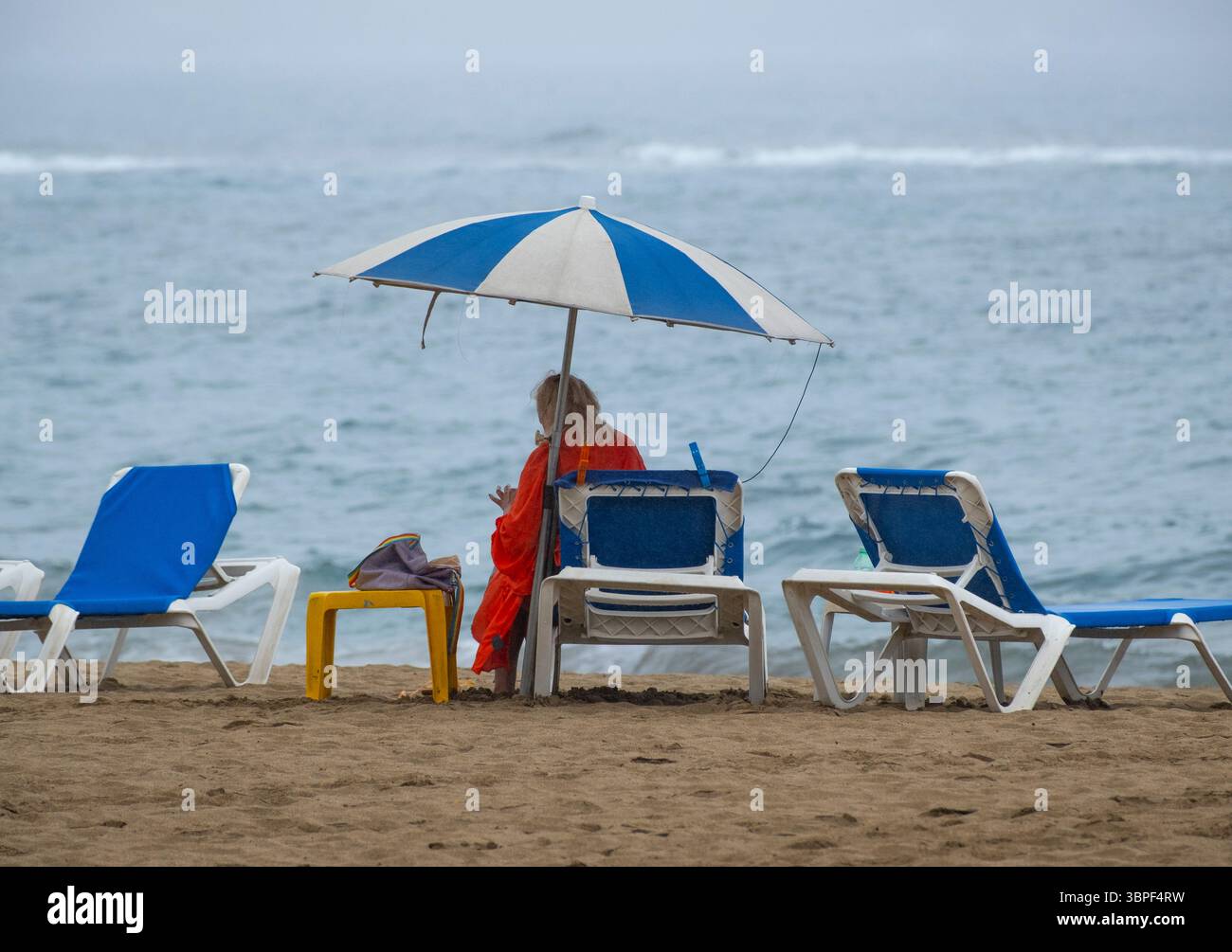 Las Palmas, Gran Canaria, Canary Islands, Spain. 8th July, 2025. A few hardy tourists, mainly British, brave an unusual spell of summer rain on the city beach in Las Palmas as rain clouds replace the usually guaranteed summer sunshine and cloudless skies. Credit: Alan Dawson/Alamy Live News Stock Photo
