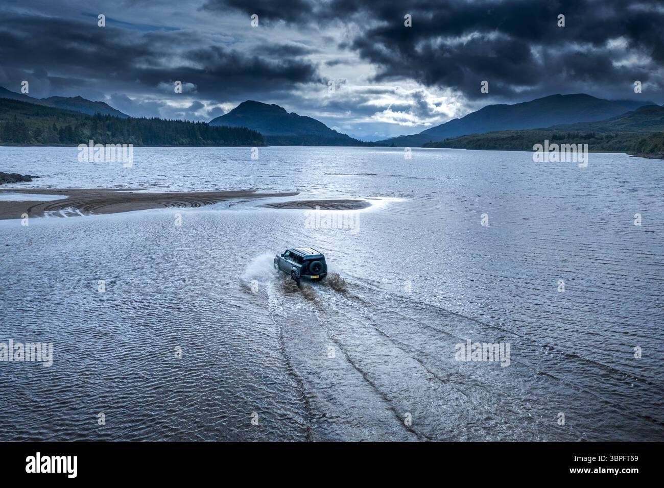 Brooding Estate Aerial view of a vehicle driving through water at Ardverikie Estate ...