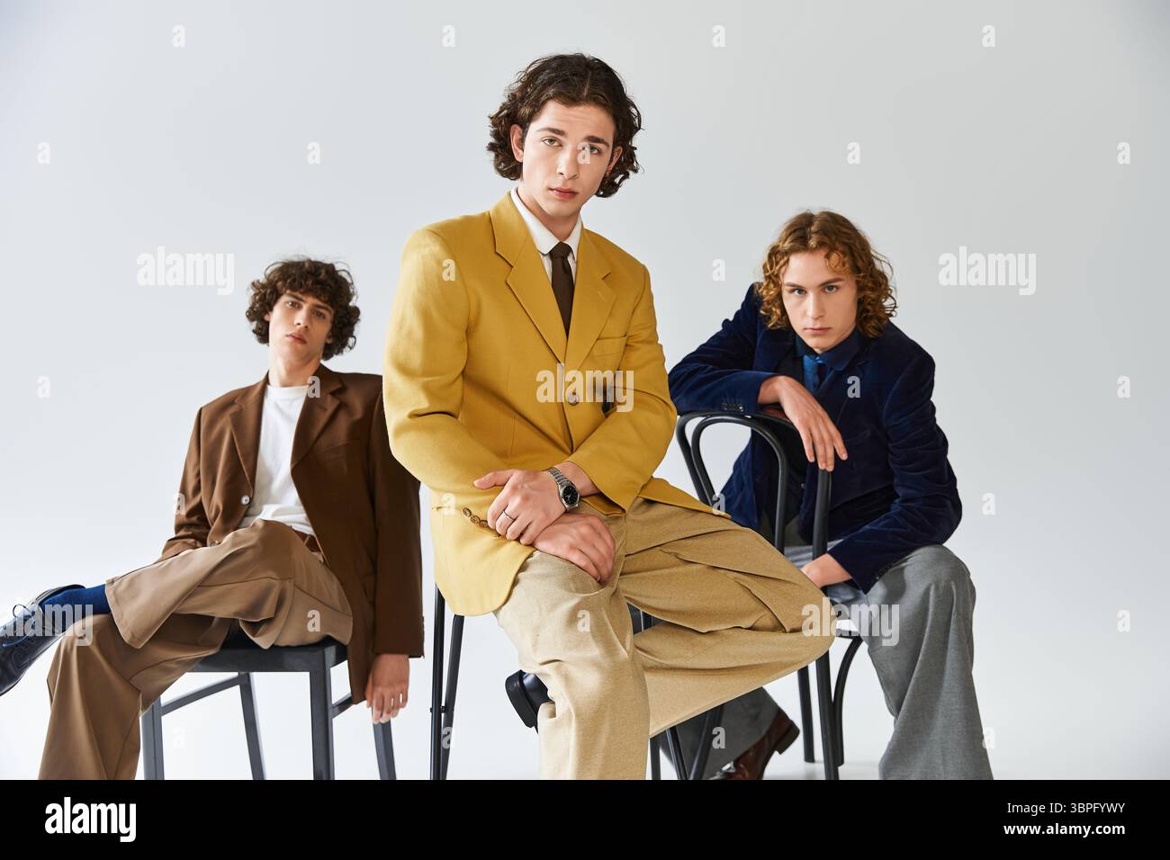 Three young men display their unique style while posing creatively with confidence and flair Stock Photo