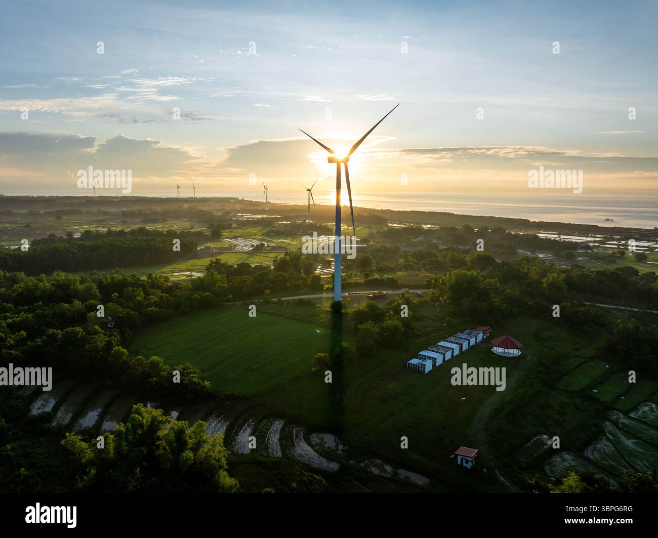 Aerial view of wind turbines standing tall against the golden sunset ...