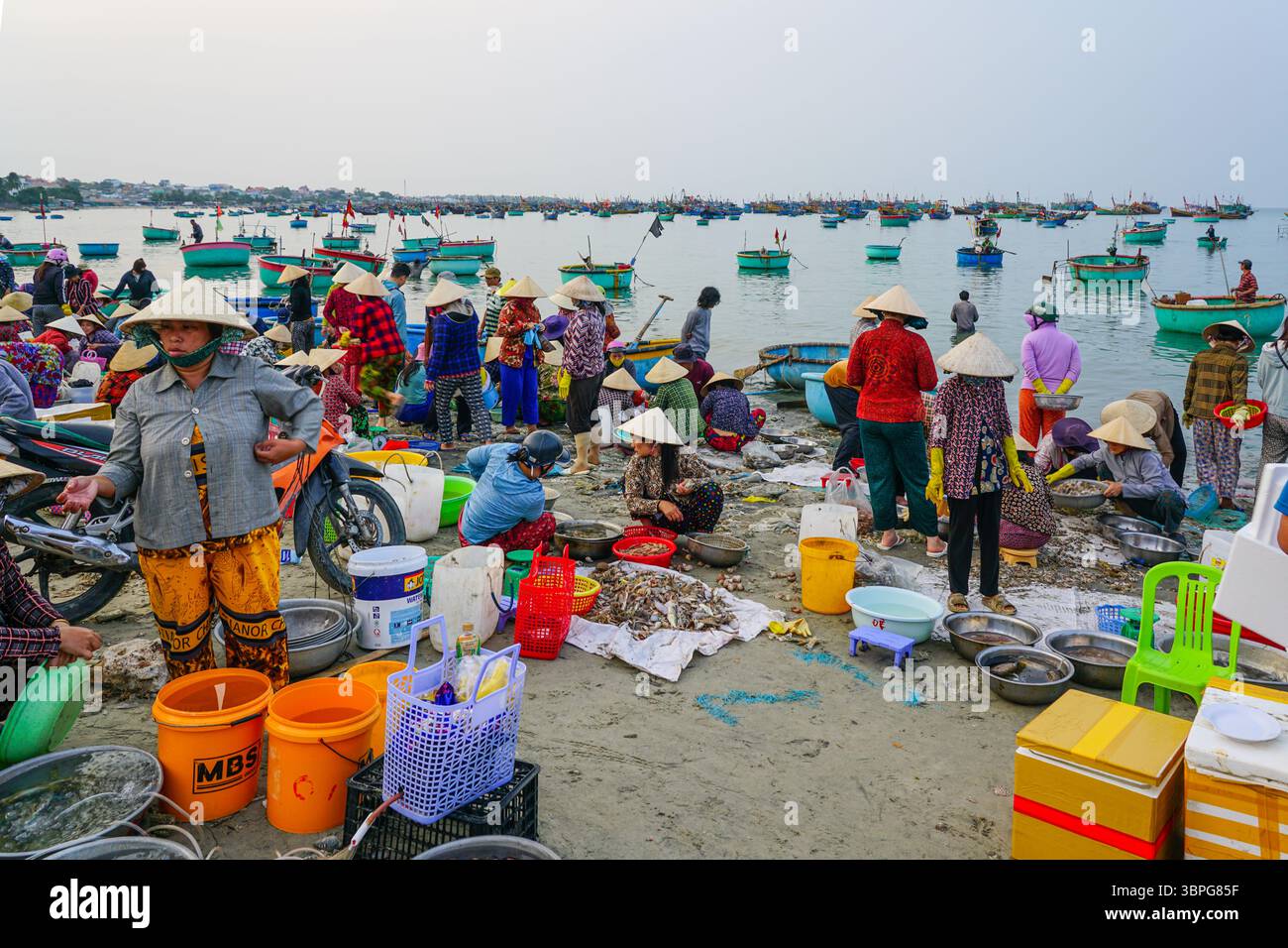 Mui Ne, Vietnam- March 22, 2025: Fishermen and vendors gather on Mui Ne ...