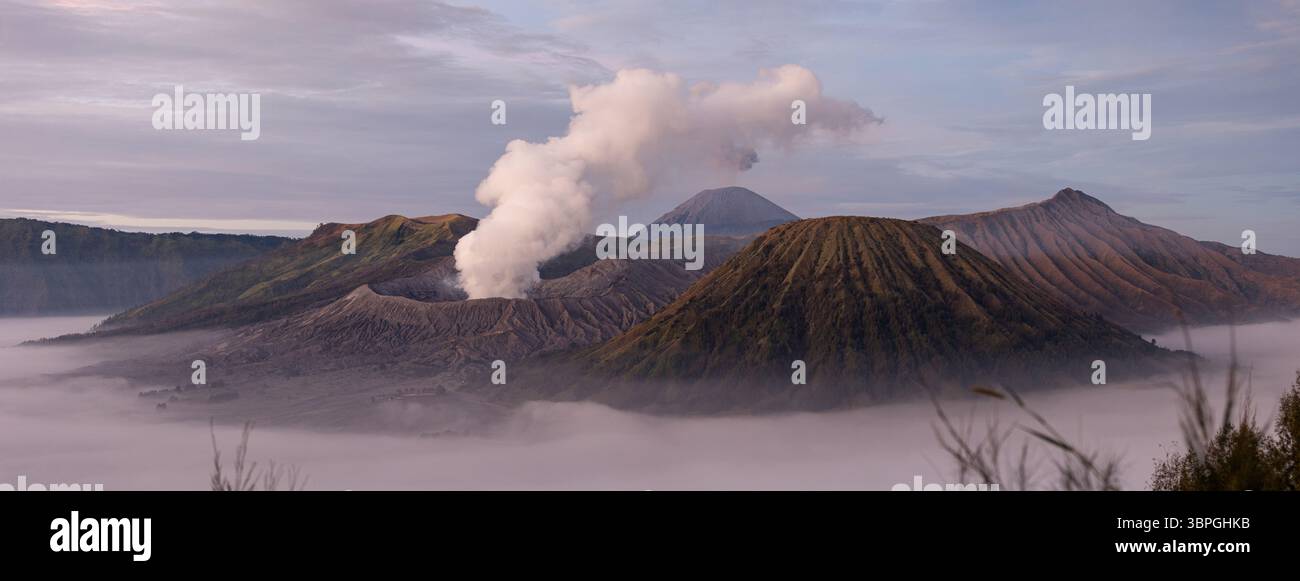 View of majestic volcanoes piercing through a sea of clouds, with white ...