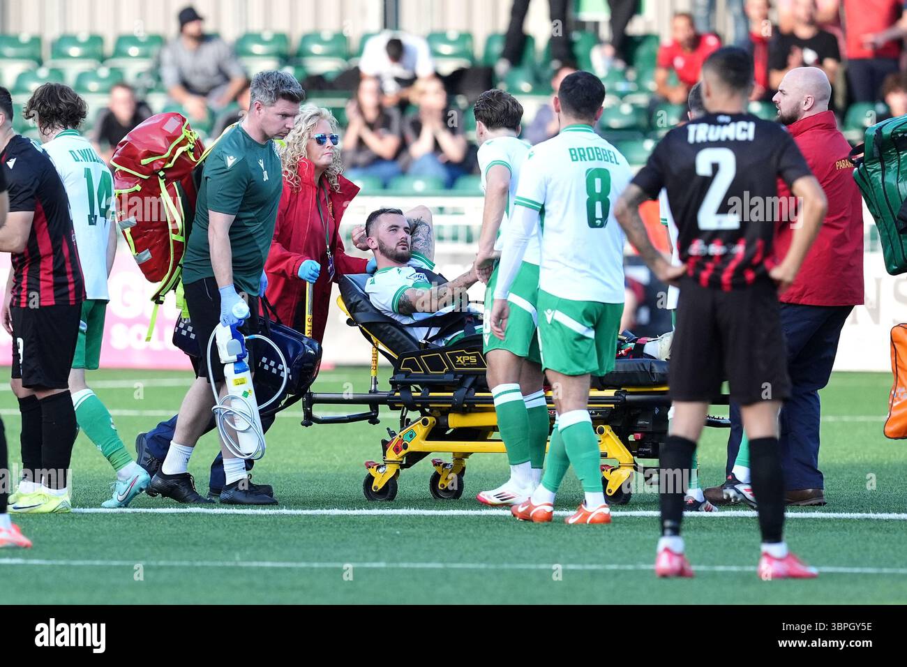The New Saints' Leo Smith (centre) is stretched off the field following ...