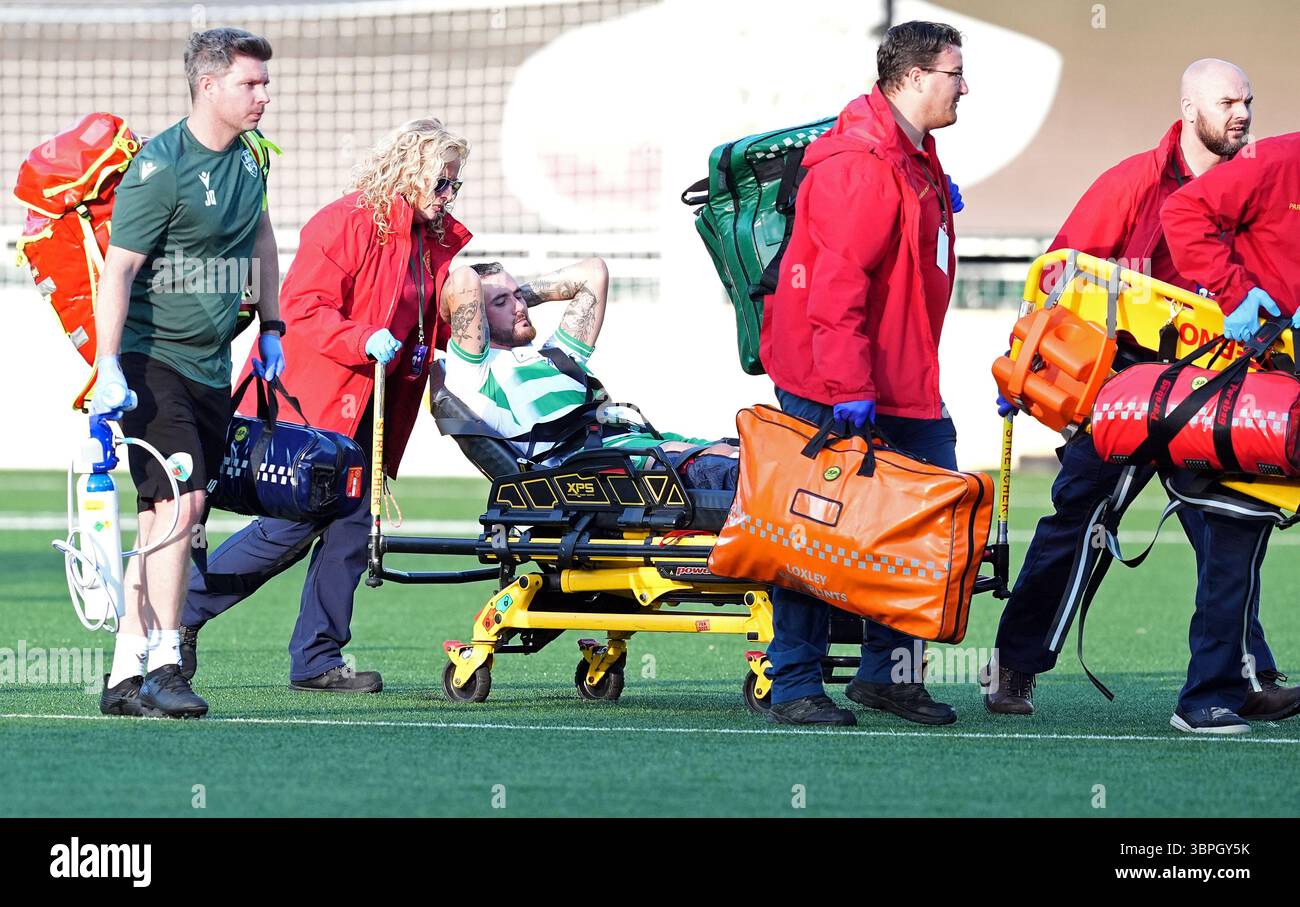 The New Saints' Leo Smith (centre) is stretched off the field following ...