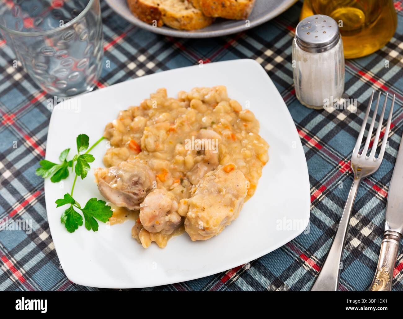 Oven-baked rabbit leg with braised beans in bowl, top view Stock Photo ...
