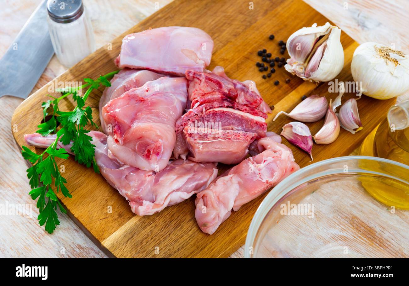 Delicious cutting rabbit meat with spices and herbs on kitchen board Stock Photo