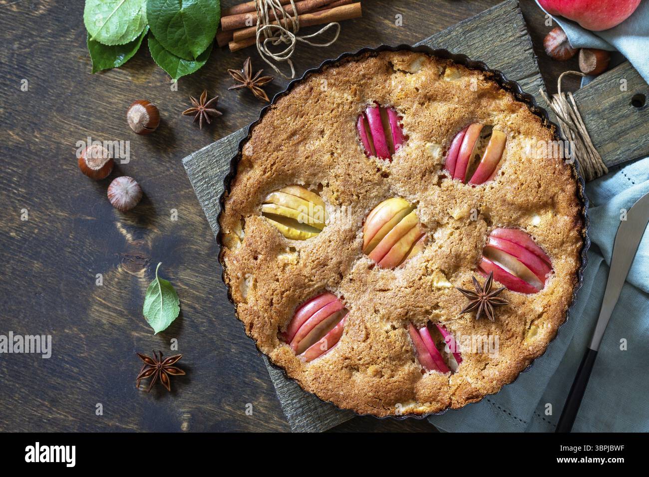 Apple baking gluten free seasonal. Autumn pie with apples, hazelnut and cinnamon on a wooden table. Top view flat lay background. Copy space Stock Photo