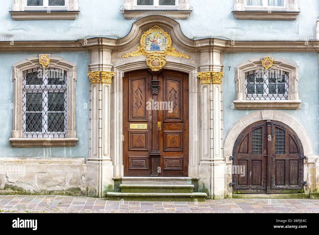 The rococo-style closed door to a manor house with flanking barred ...