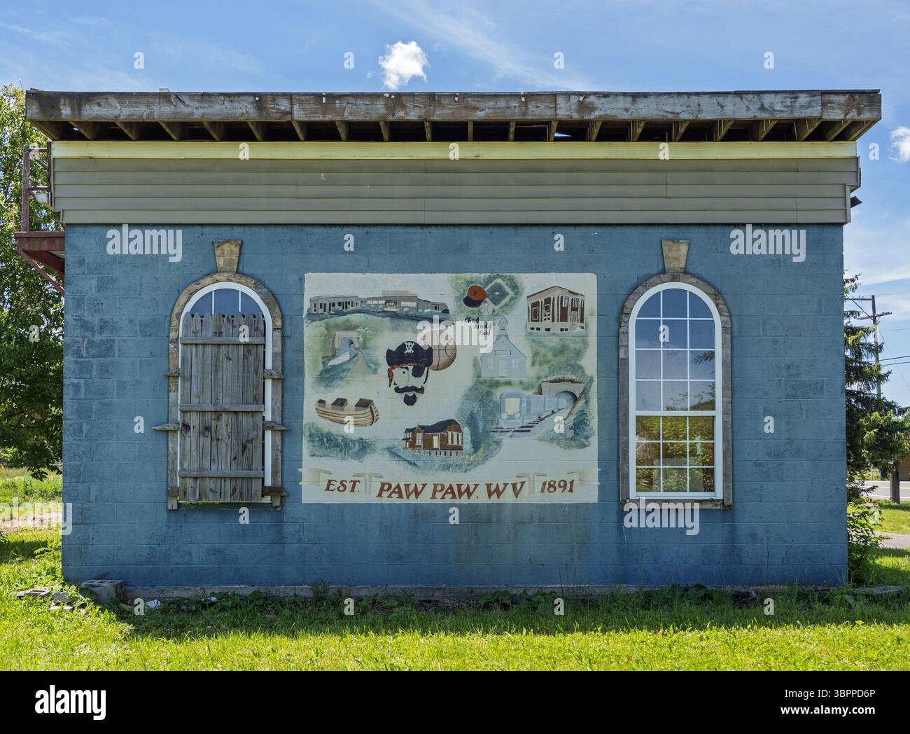 An outdoor shot of a building in Paw Paw, West Virginia, featuring a detailed mural of local history and distinct windows. Stock Photo