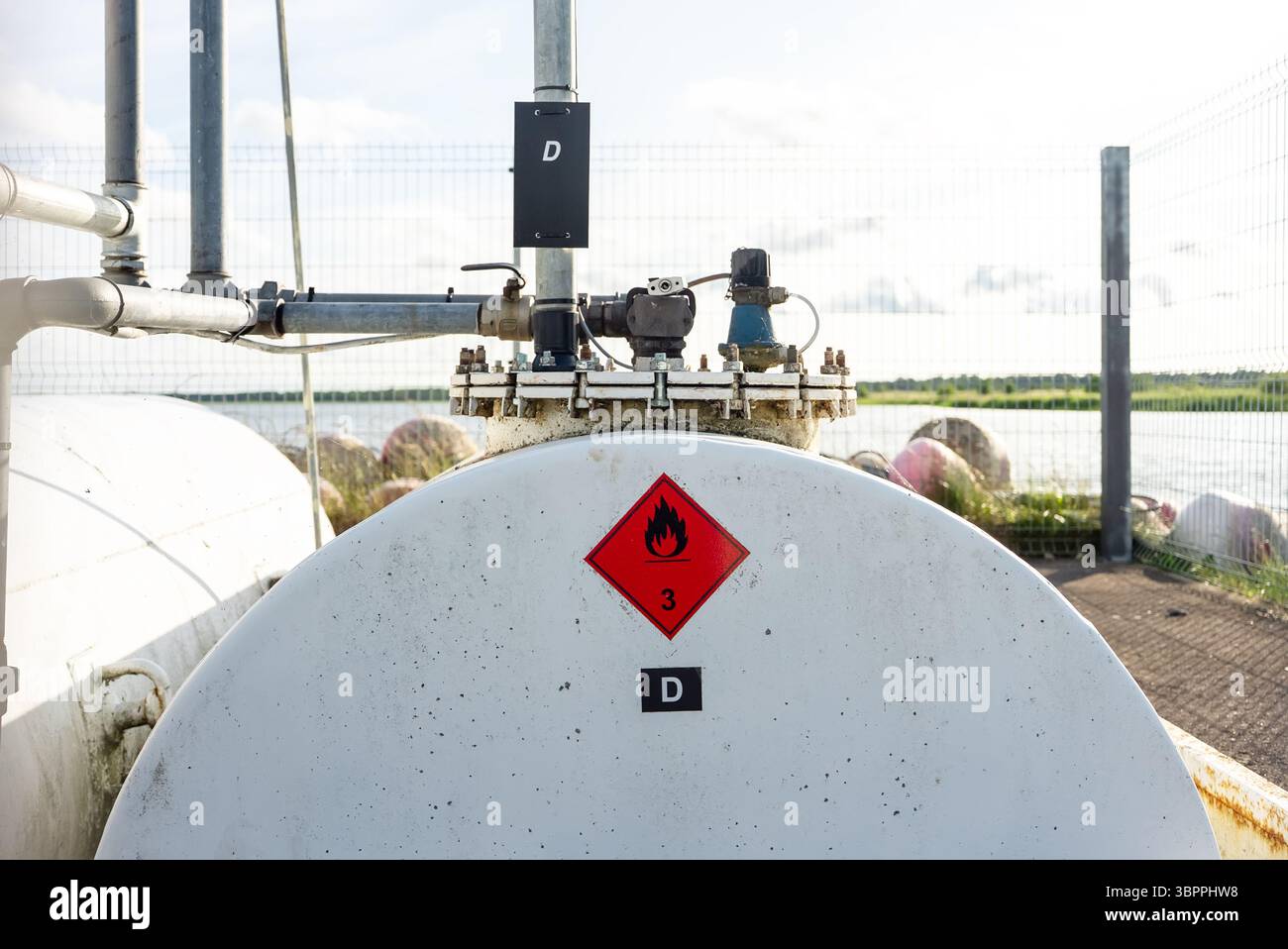 Industrial fuel storage tank with warning labels and piping system ...