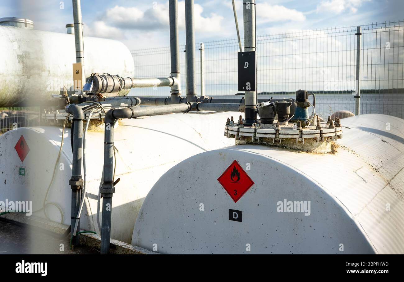 Tank Inactive Label Industrial fuel storage tank with warning labels and piping system ...