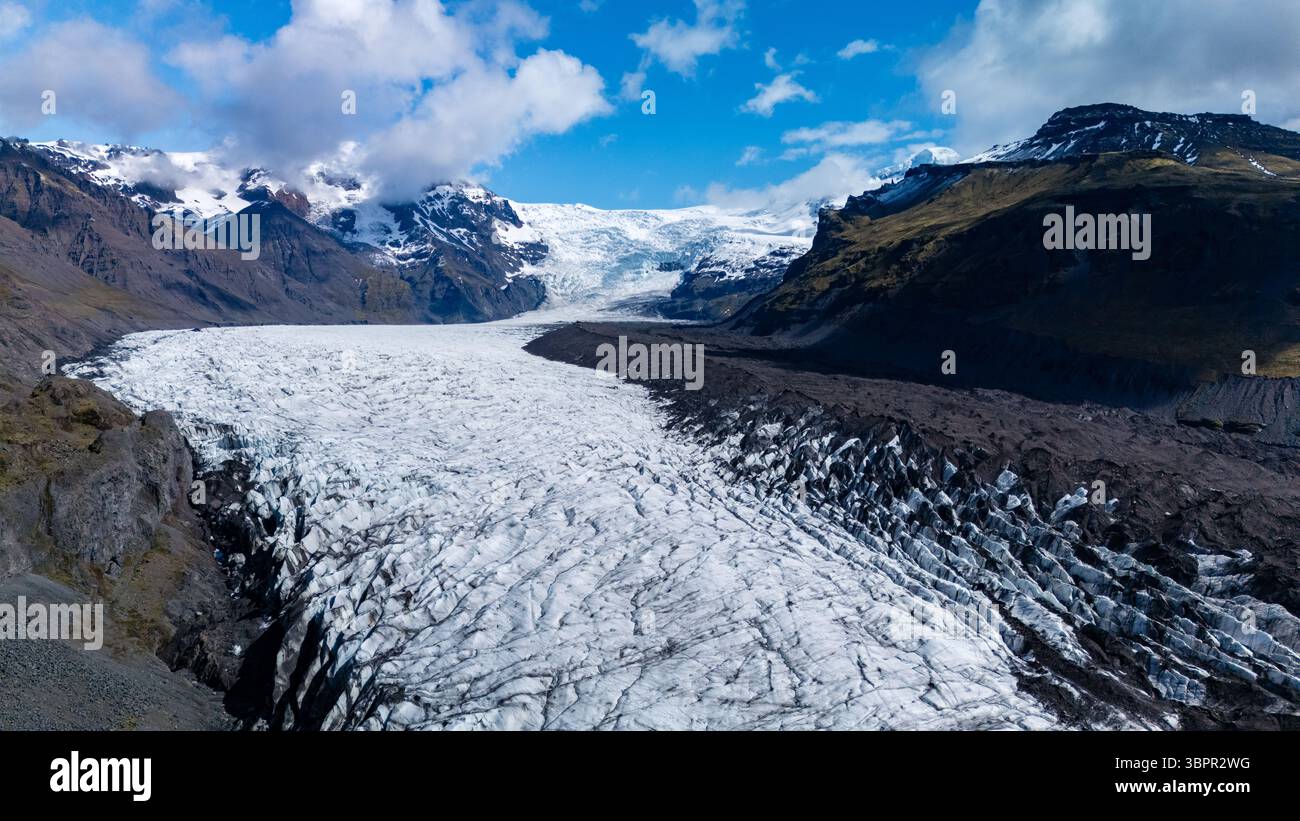 Enjoy breathtaking views of Svinafellsjokull Glacier, where glacial ice meets rugged mountains under vibrant skies. This stunning landscape captures the essence of Icelands natural beauty. Stock Photo