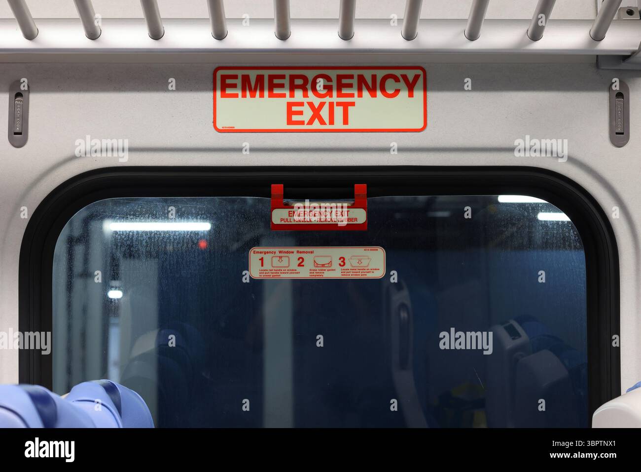 Signage and instruction sof an Emergency Exit through the window of an American passenger railroad train car Stock Photo