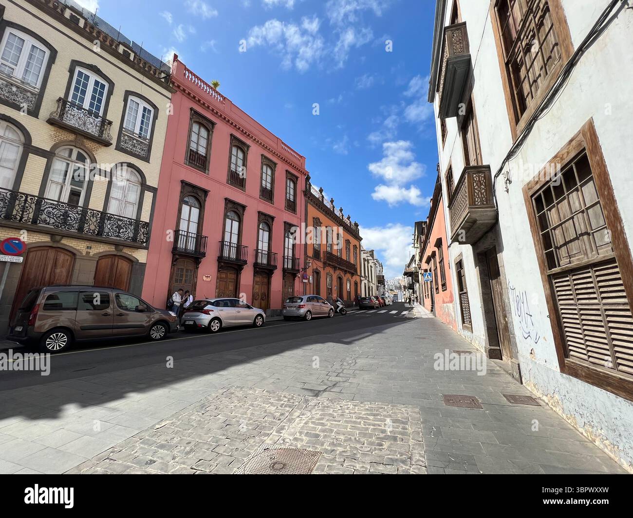 Las Palmas, Canary Islands, Spain - Mars 13, 2022. A stunning pink building with intricate architectural details stands against a bright blue sky. - Smartphone Captured Stock Image
