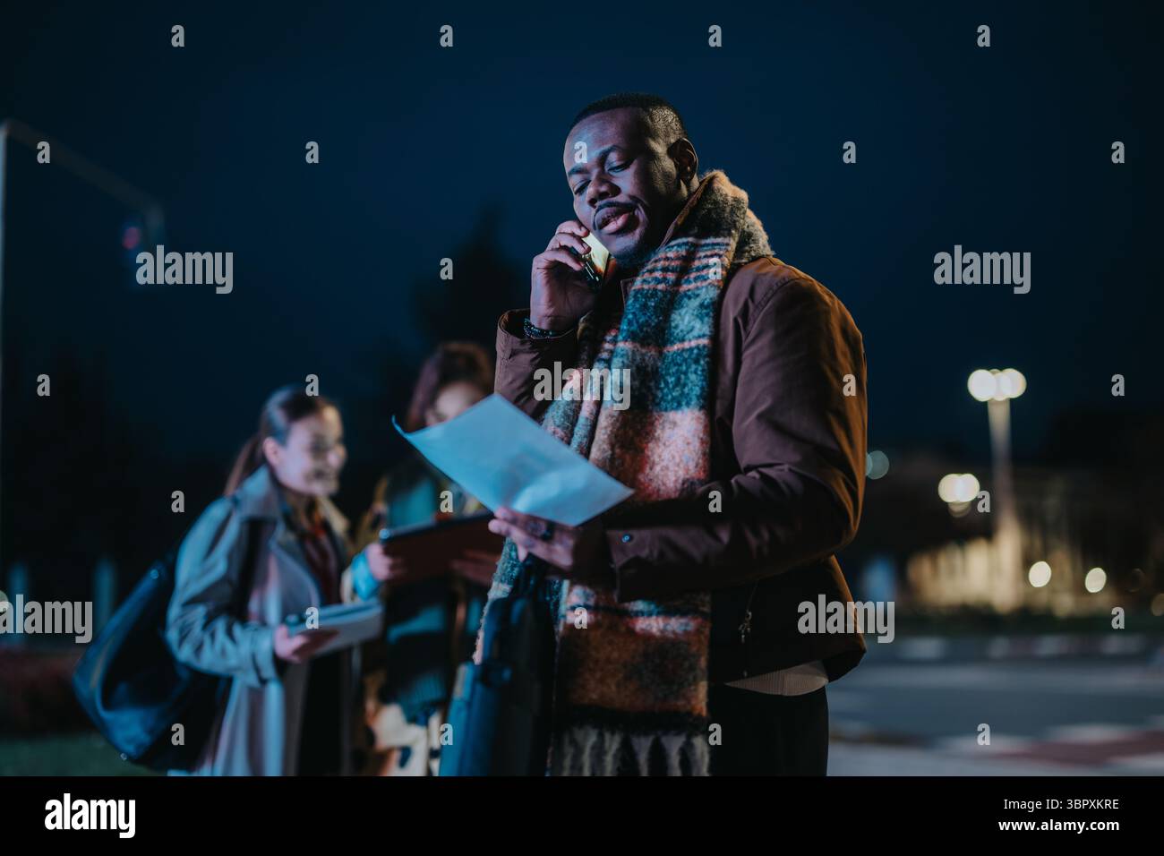 Multiracial people collaborating outside during the evening, embracing teamwork in a dynamic setting Stock Photo