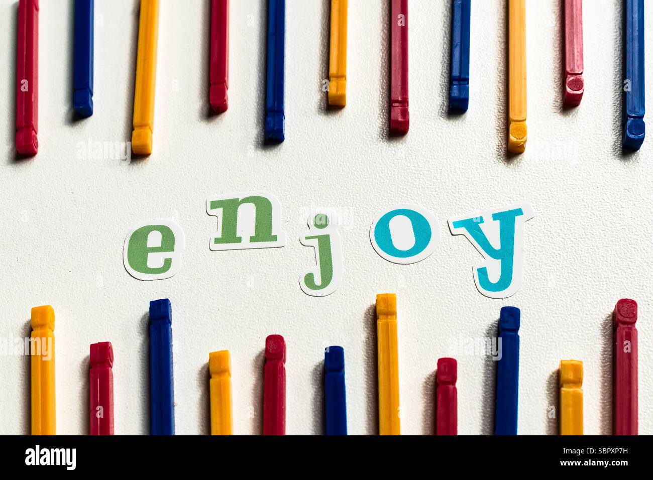 Colorful sticker word 'ENJOY' surrounded by vibrant plastic sticks on ...