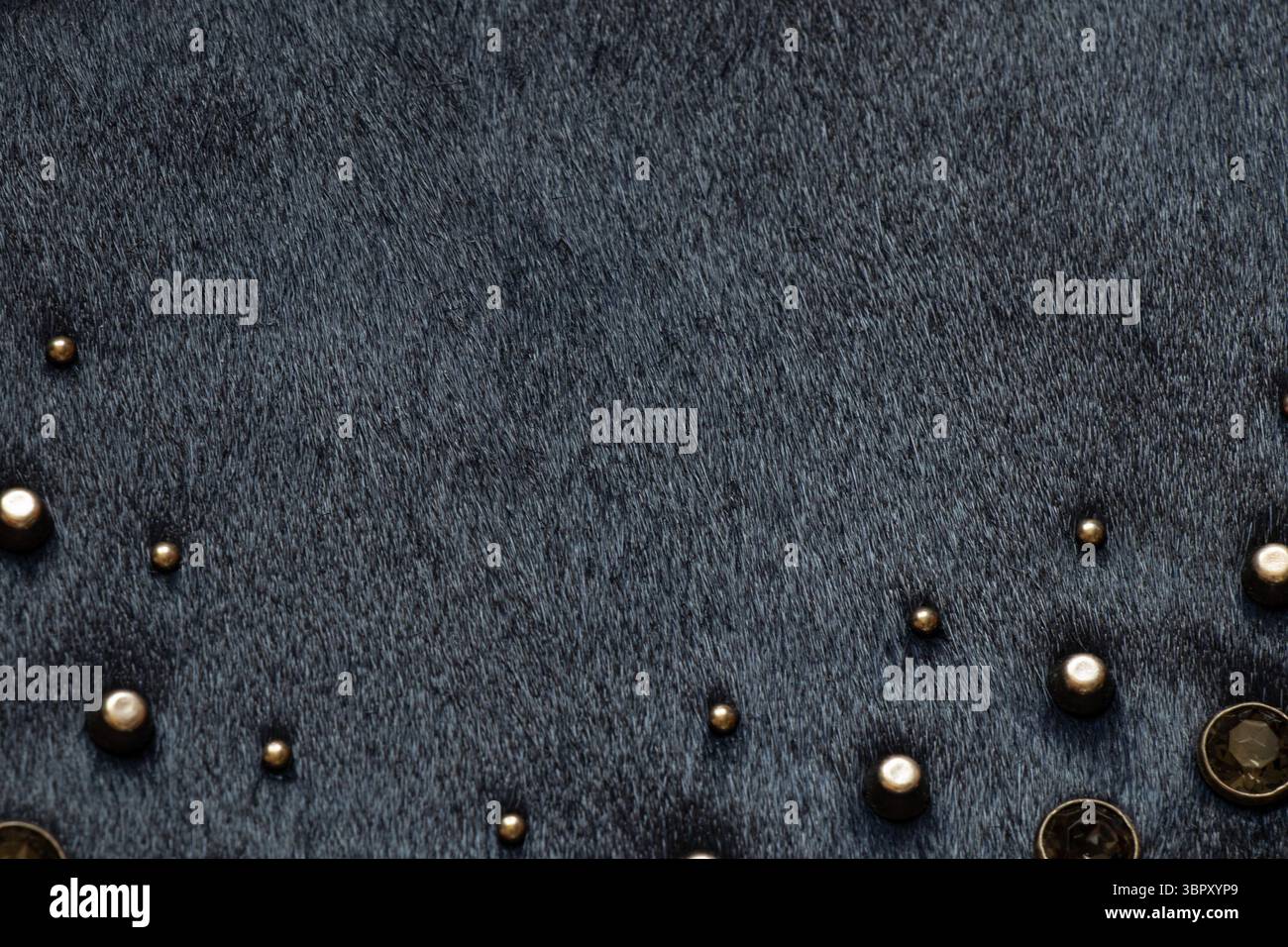 Dark fur with metal decorations, background and texture of black women's bag close-up Stock Photo