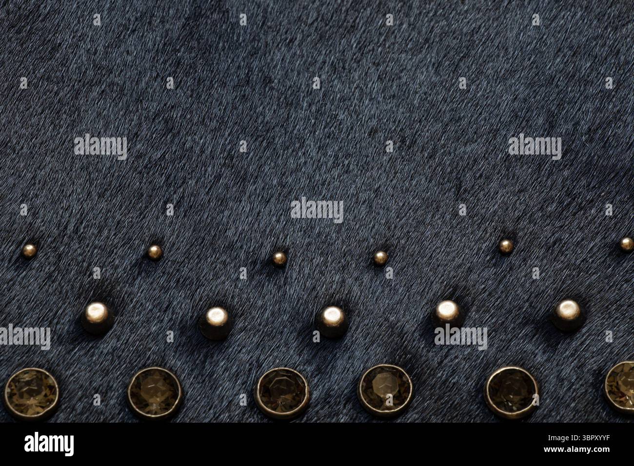 Dark fur with metal decorations, background and texture of black women's bag close-up Stock Photo