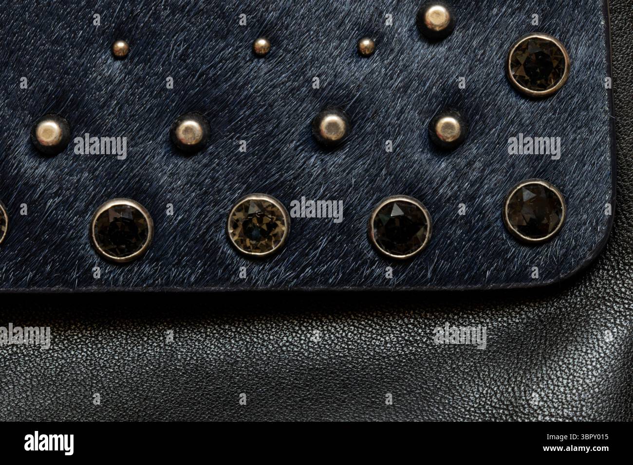 Dark fur with metal decorations, background and texture of black women's bag close-up Stock Photo