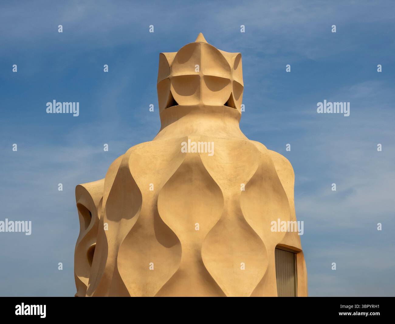 A sculptural stairwell with a cross-shaped top against a blue sky on the roof of Casa Milà (La Pedrera), an icon of modernist design, Barcelona. Stock Photo