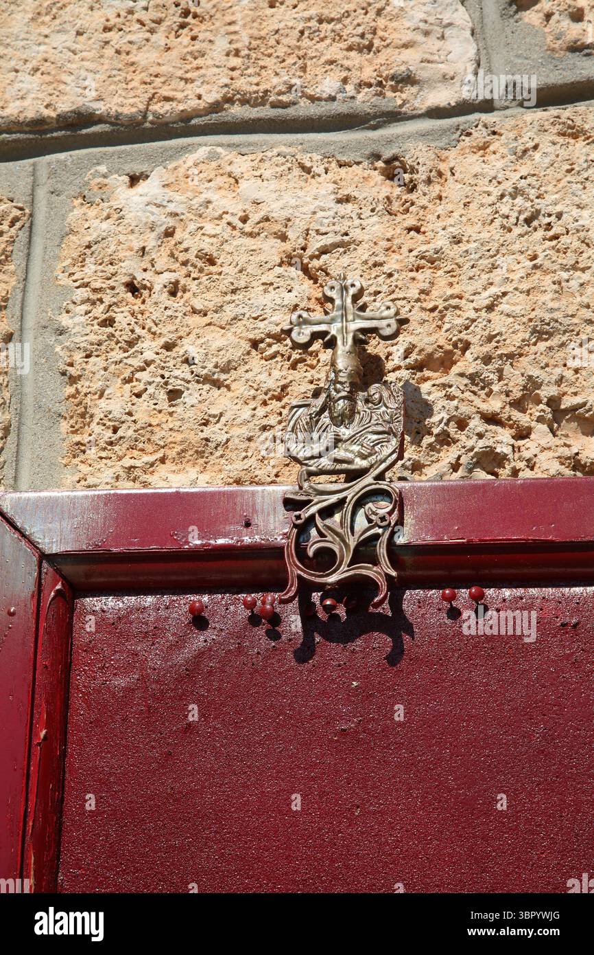 Metal Cross above Empty Red Noticeboard and pins outside  at Agios Nikolas Church Vari-Voula- Vouliagmeni Attica Greece Stock Photo