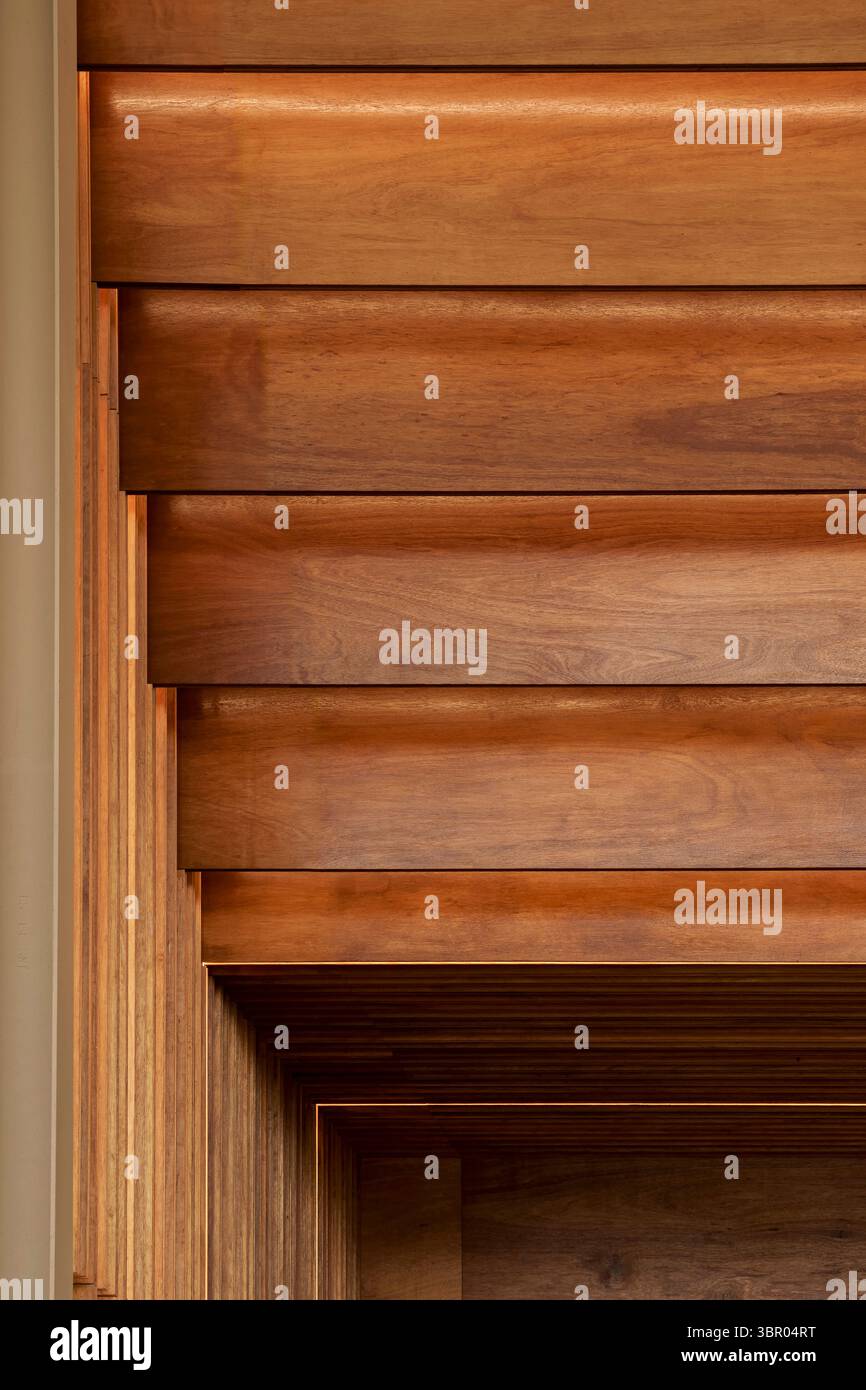 Close-up detail of layered wooden wall panels with warm, recessed LED ...