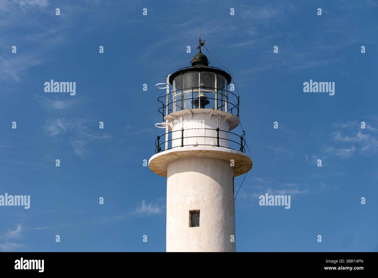 A classic white lighthouse tower with its lantern room and railing, set ...