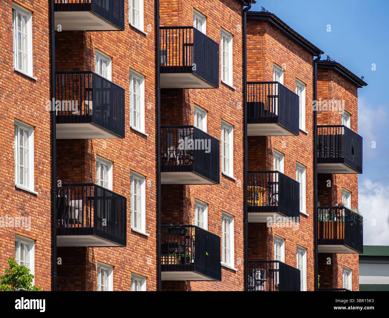 A close-up view of modern apartment buildings featuring red brick ...