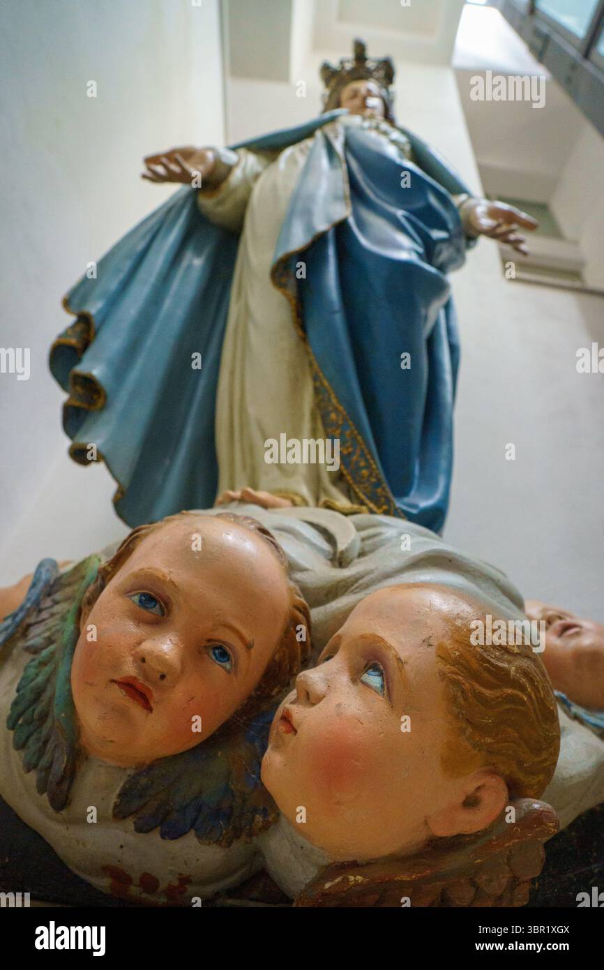 A close-up of a statue of the Virgin Mary, adorned with a golden crown ...
