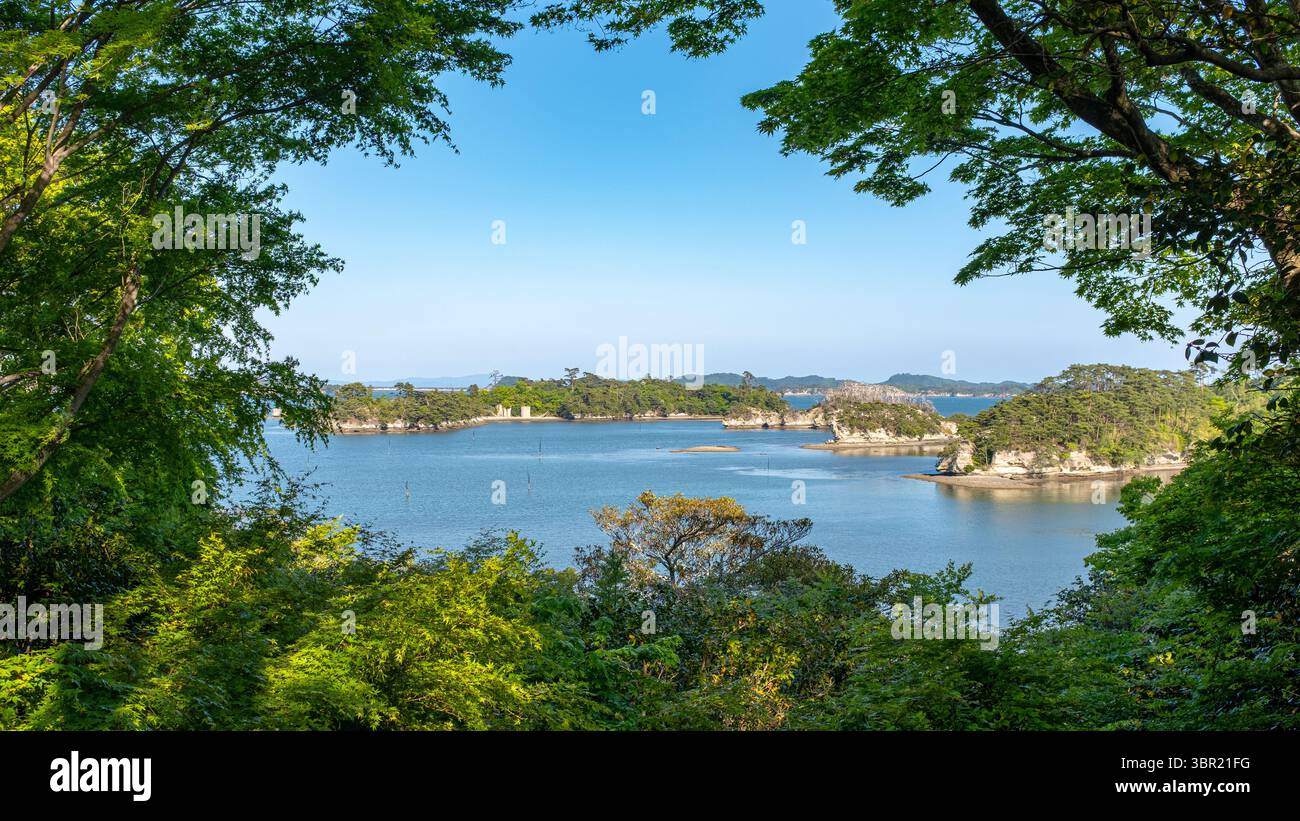 A tree framed view of the islands of the bay of Matsushima, Japan, taken on a sunny springtime day with no people. Stock Photo