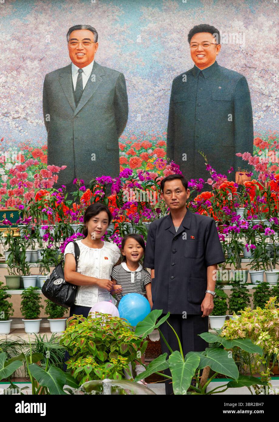 Family posing in front of the Leaders at the international Kimilsungia ...